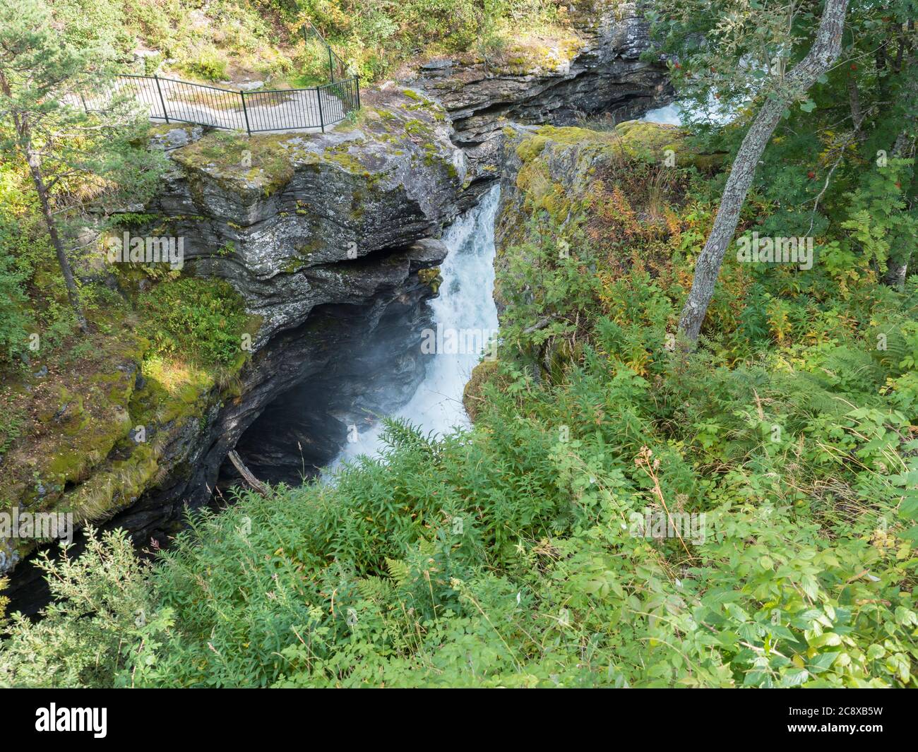 Cascade de Slettafossen à Verma avec point de vue plate-forme profond et étroit canyon de la rivière Rauma dans la vallée de Romsdalen avec des rochers et une forêt verte. Bleu ciel blanc Banque D'Images