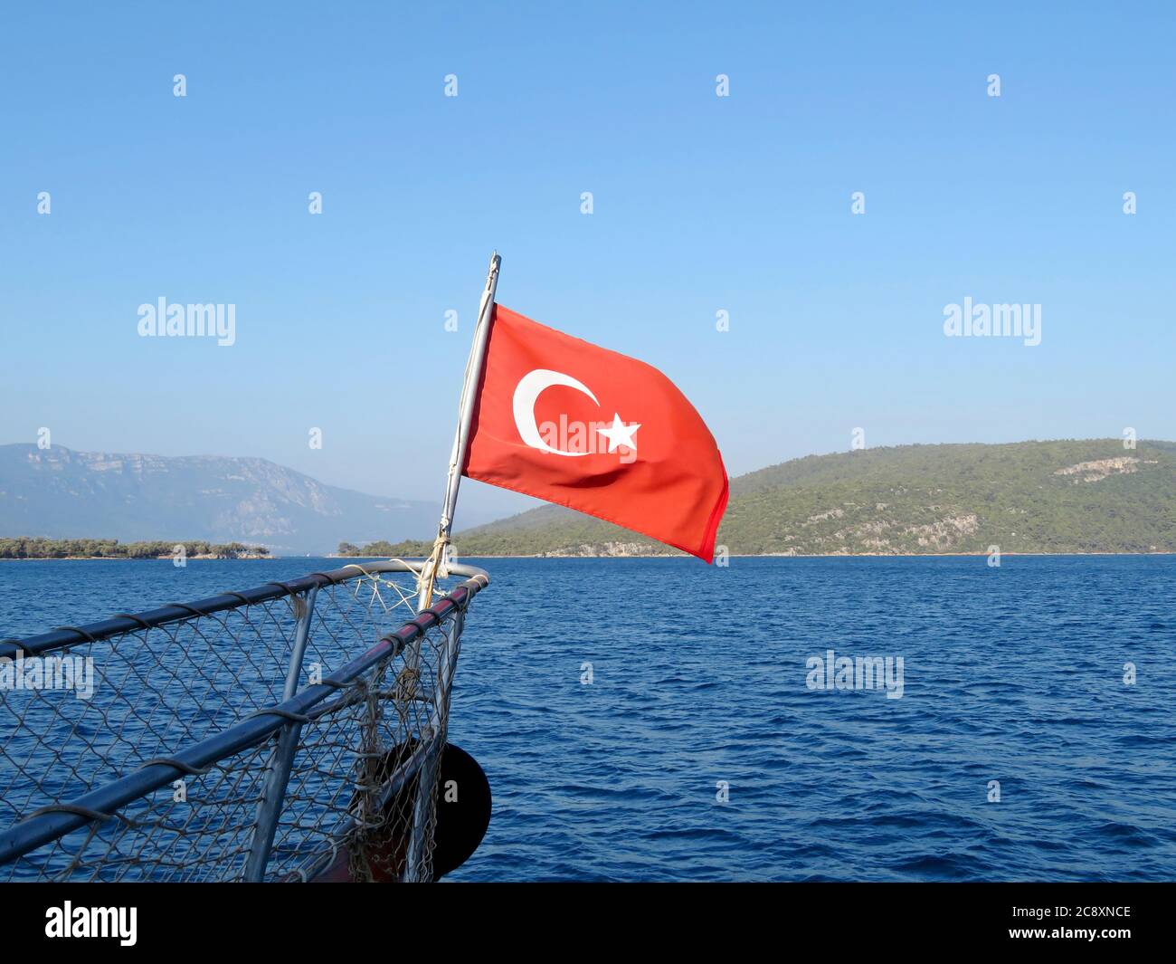 Drapeau de la Turquie sur le nez du navire, concept de voyage. Côte turque en été, vue sur la mer Méditerranée avec îles Banque D'Images