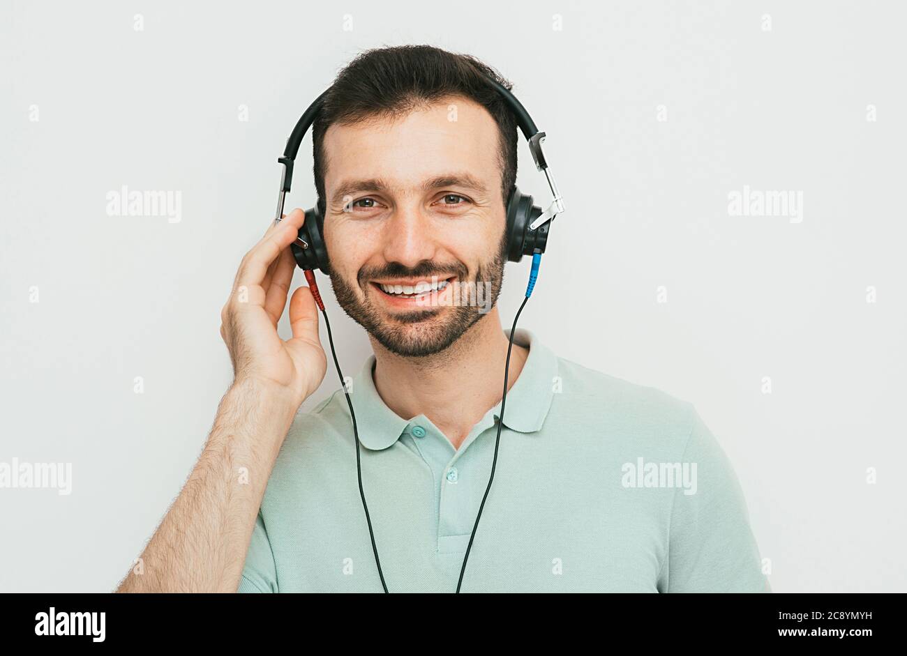 Test auditif, diagnostic auditif. Un homme portant un casque ayant un test d'audiométrie isolé en blanc Banque D'Images