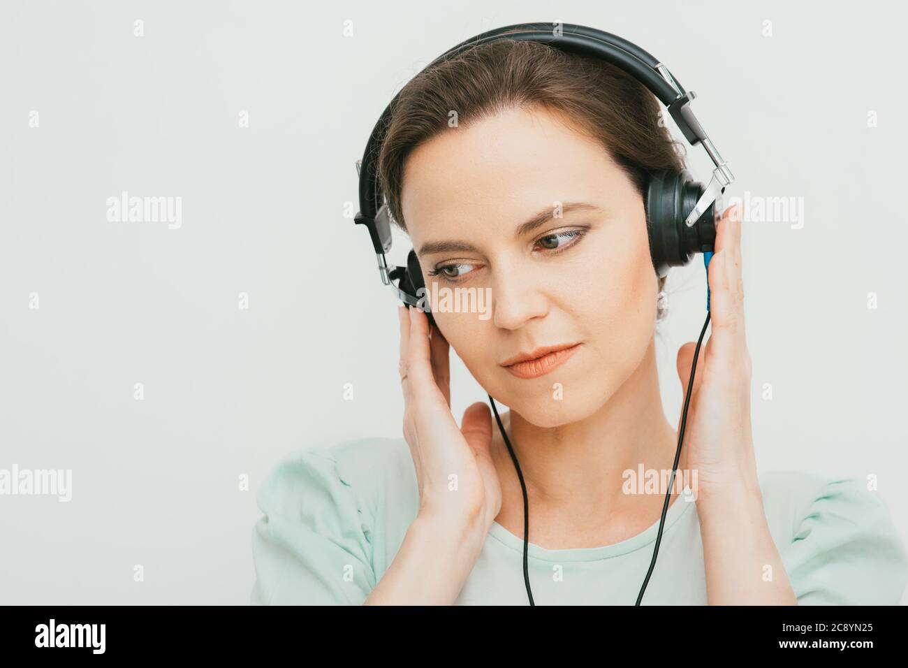 Test auditif, diagnostic auditif. Une femme portant un casque ayant un test d'audiométrie isolé en blanc Banque D'Images
