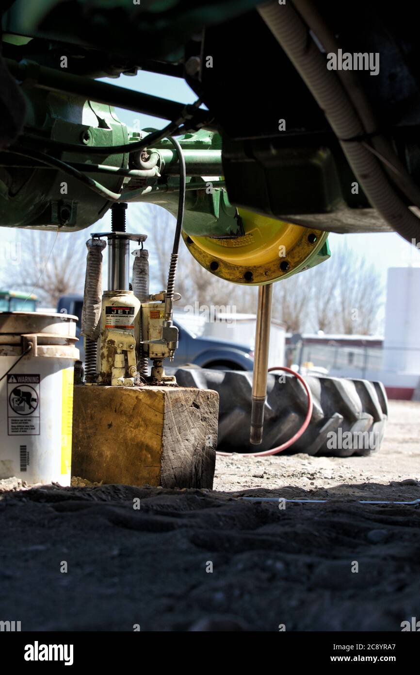 Fort Hall, Idaho, UISA 4 avril 2013 réparation de l'essieu avant sur un tracteur qui s'est cassé dans le champ. Banque D'Images