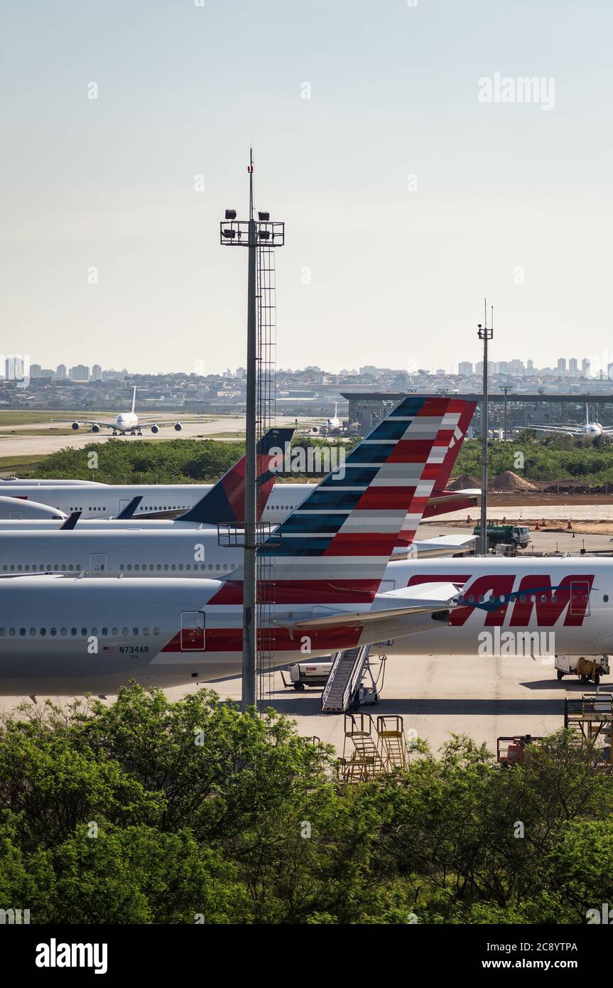 Stabilisateurs verticaux de divers avions garés dans une zone éloignée de l'aéroport international de Sao Paulo/Guaruhos. Aéroport alors que la circulation terrestre est taxante en arrière-plan lointain. Banque D'Images