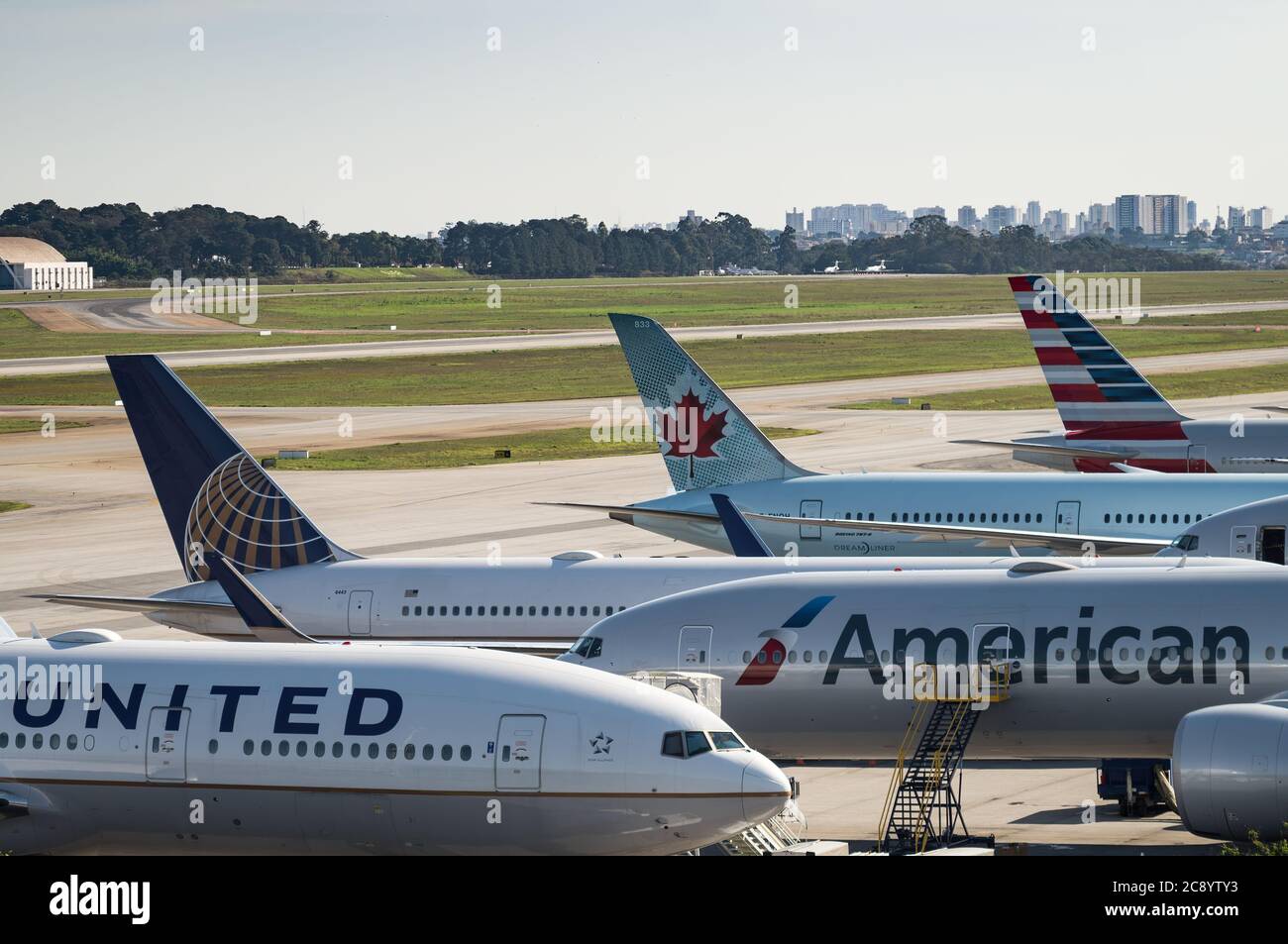 Stabilisateurs verticaux des principaux avions de ligne stationnés dans la zone éloignée de l'aéroport international de Guarulhos. Aéroport. Des avions vous y attendent tout en étant entretenus par la manutention au sol. Banque D'Images