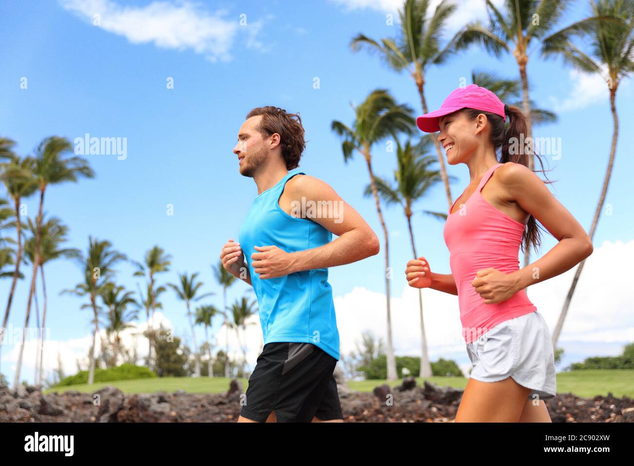 Couple heureux courir ensemble entraînement le matin été vivre un style de vie sain. Des personnes interraciales s'y sont sorties dans le parc d'été Banque D'Images
