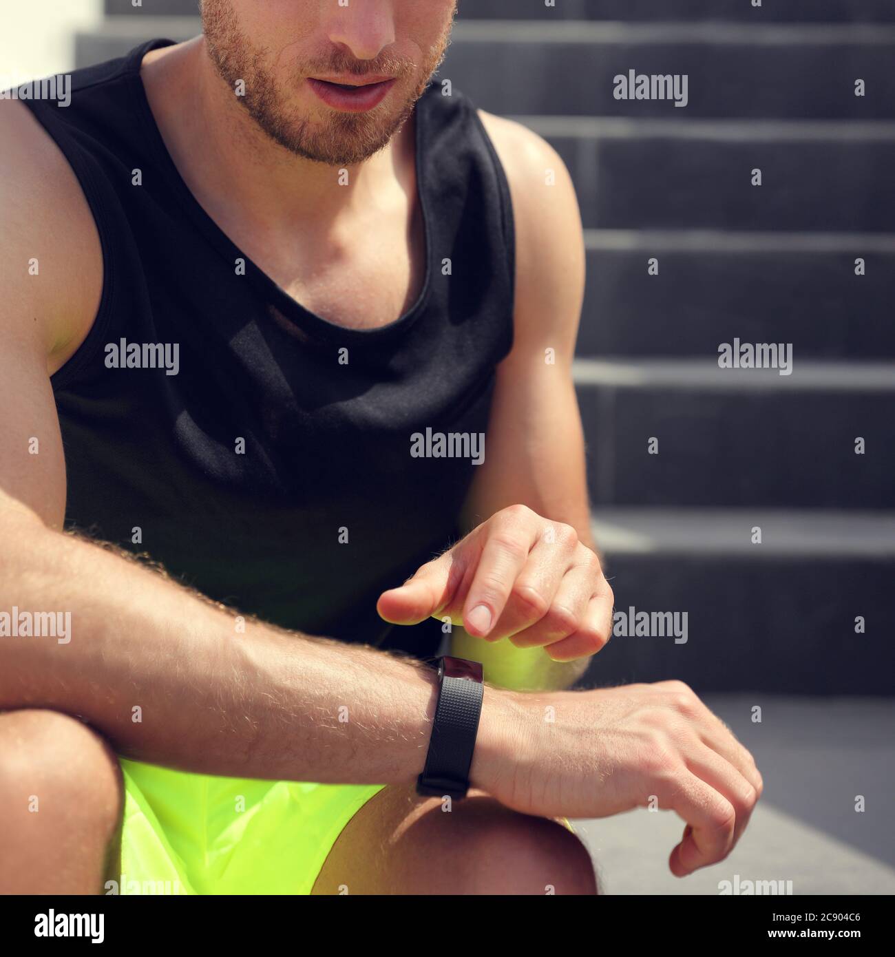 Montre de sport intelligente homme de forme physique touchant montre de sport avant de courir sur l'entraînement d'escalier. Gros plan du poignet et de la main Banque D'Images