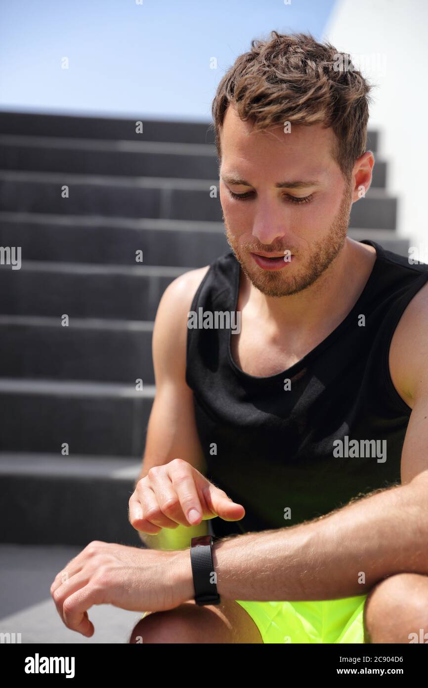 Coureur de montre intelligente homme touchant montre sport se préparer à courir sur l'entraînement d'escalier. Un mode de vie actif sain course à pied athlète masculin s'entraîner Banque D'Images
