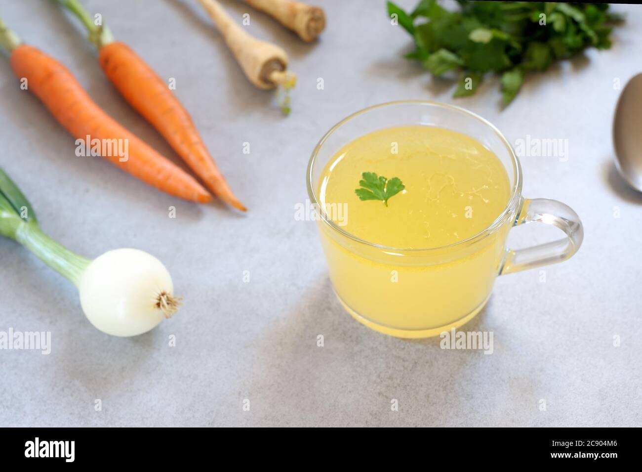 Bouillon osseux, bouillon osseux dans une tasse de verre et légumes à l'arrière-plan. Paleo Diet.horizontal,avec foyer sélectif. Banque D'Images