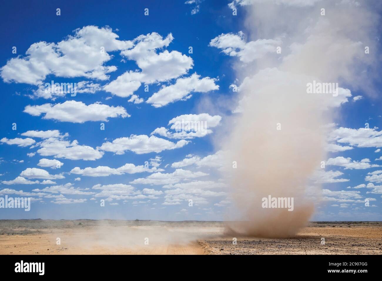 Mini tornade tourbillonnante près de la ville désertique australienne de l'Outback, Marree, tempête de sable, nuages moelleux et ciel bleu avec espace de copie, Australie méridionale Banque D'Images
