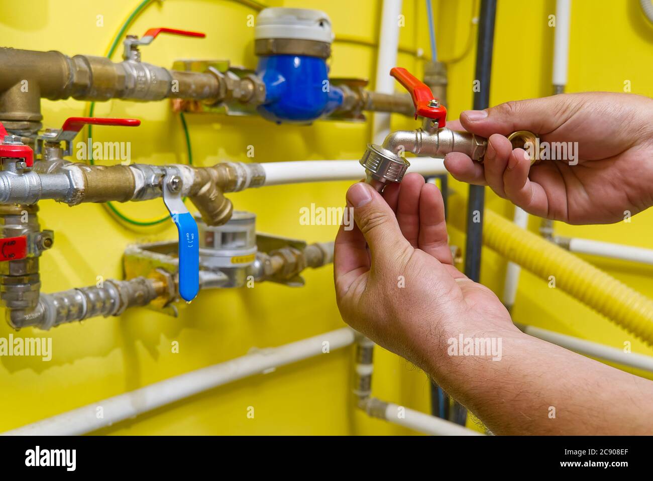 L'employé connecte un raccord rapide pour l'eau du jardin. Banque D'Images