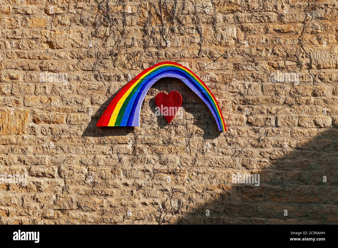 Arc-en-ciel peint sur du bois monté sur le mur de grès Banque D'Images