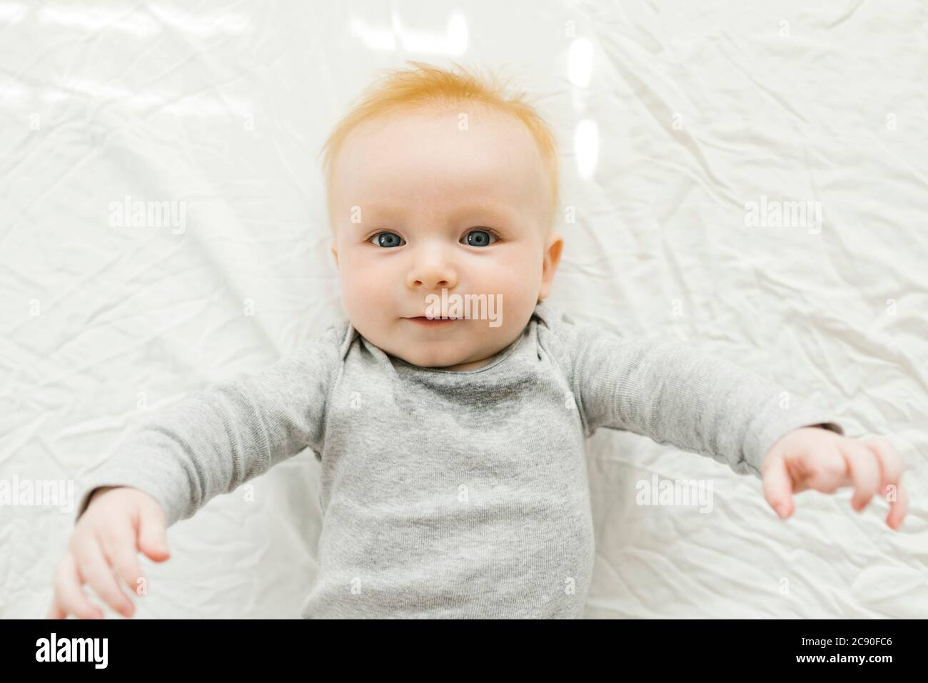 Portrait of baby boy lying on bed Banque D'Images