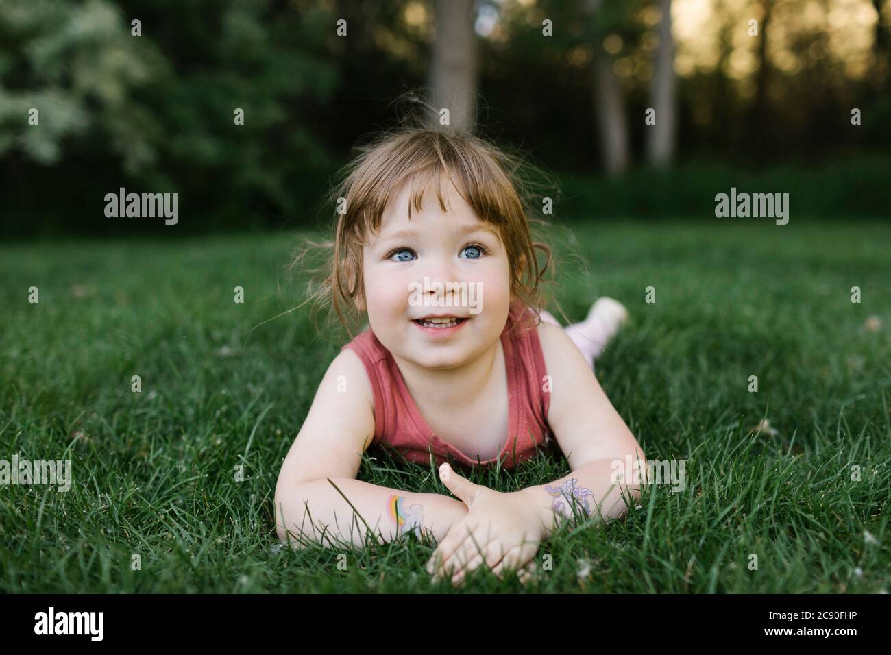 Girl (2-3) lying on grass Banque D'Images