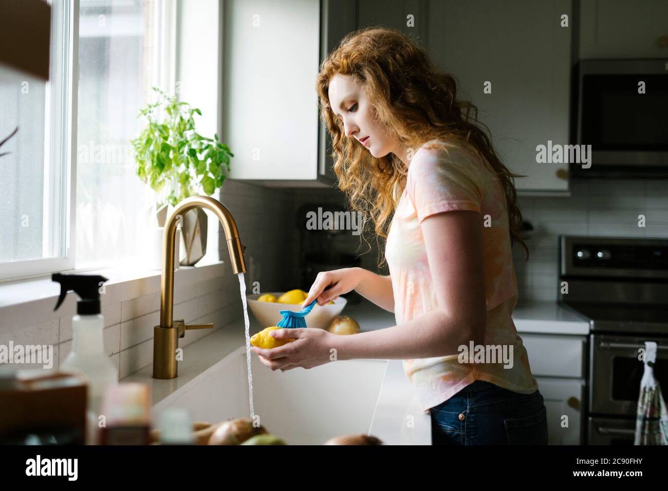 Femme lavant le citron avec la brosse Banque D'Images