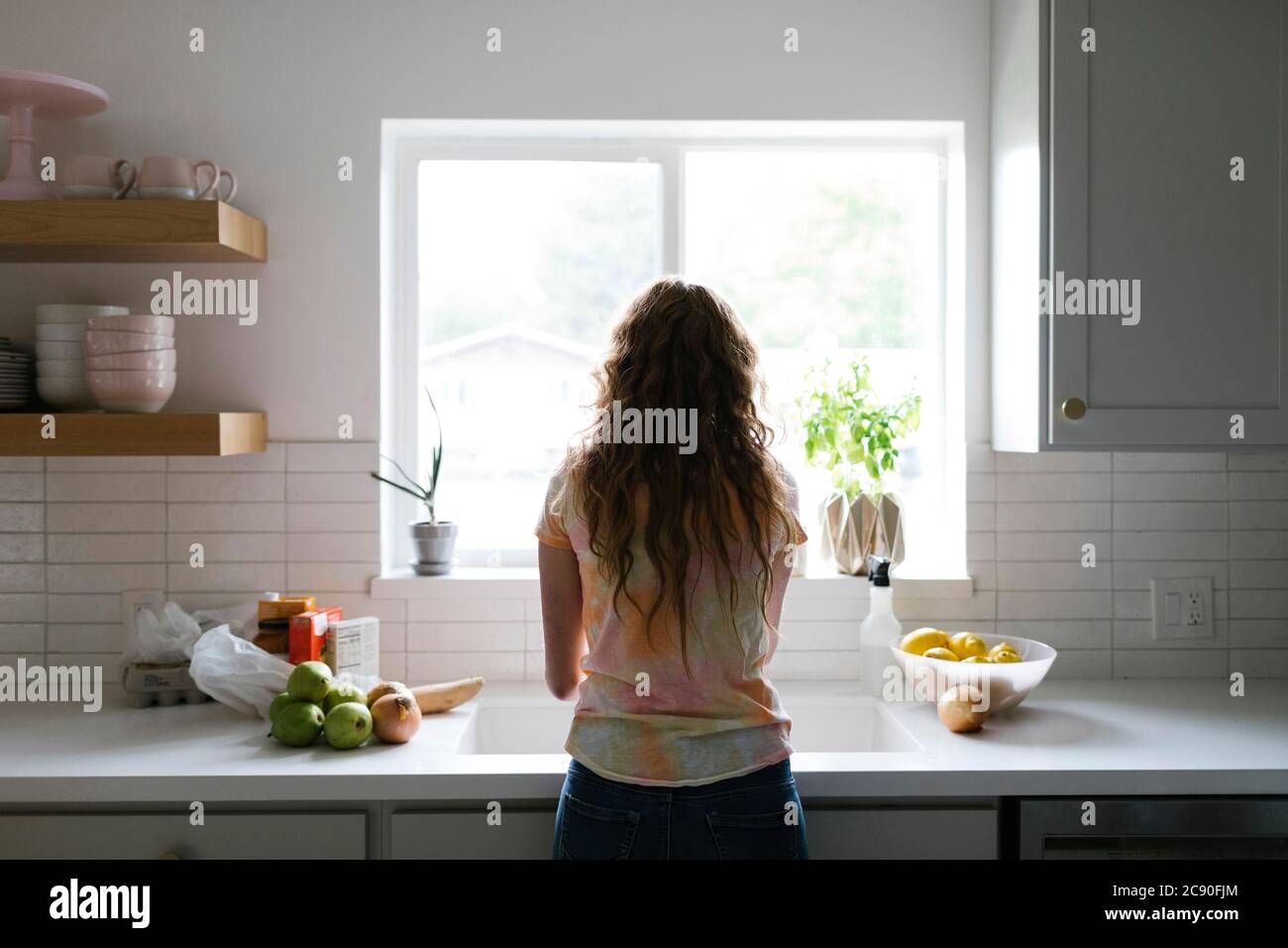 Femme lavant des fruits et des légumes dans la cuisine Banque D'Images