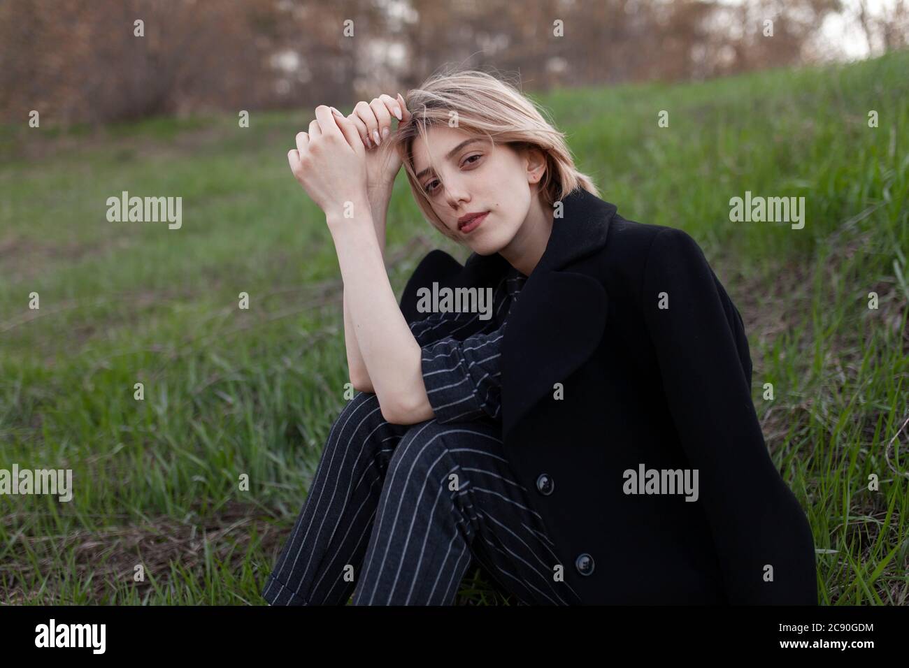 Russie, Omsk, Portrait de la jeune femme assise dans l'herbe Banque D'Images