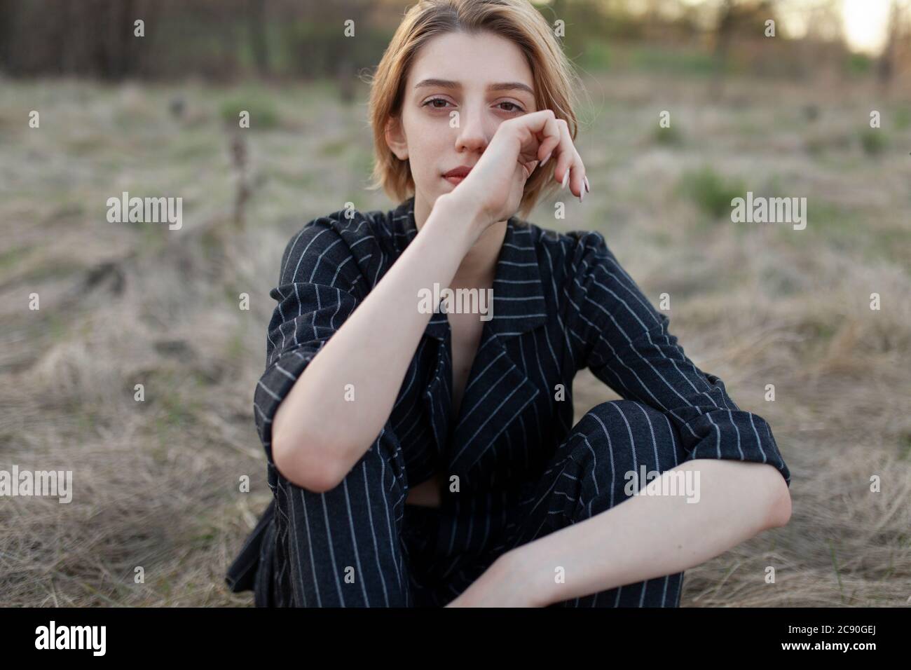Russie, Omsk, Portrait de la jeune femme assise dans l'herbe Banque D'Images