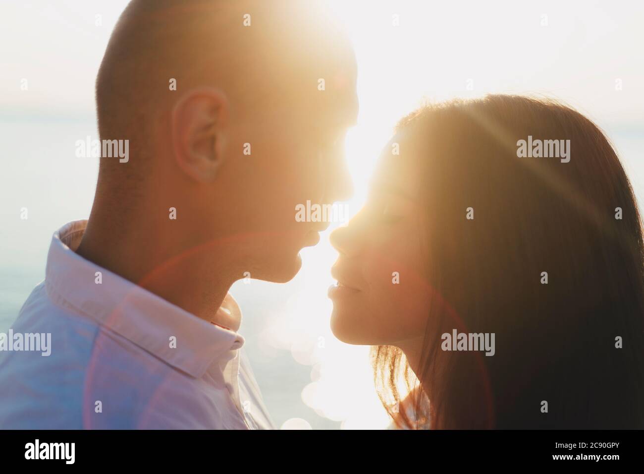 Couple face à face, rétroéclairé par rayons de soleil Banque D'Images