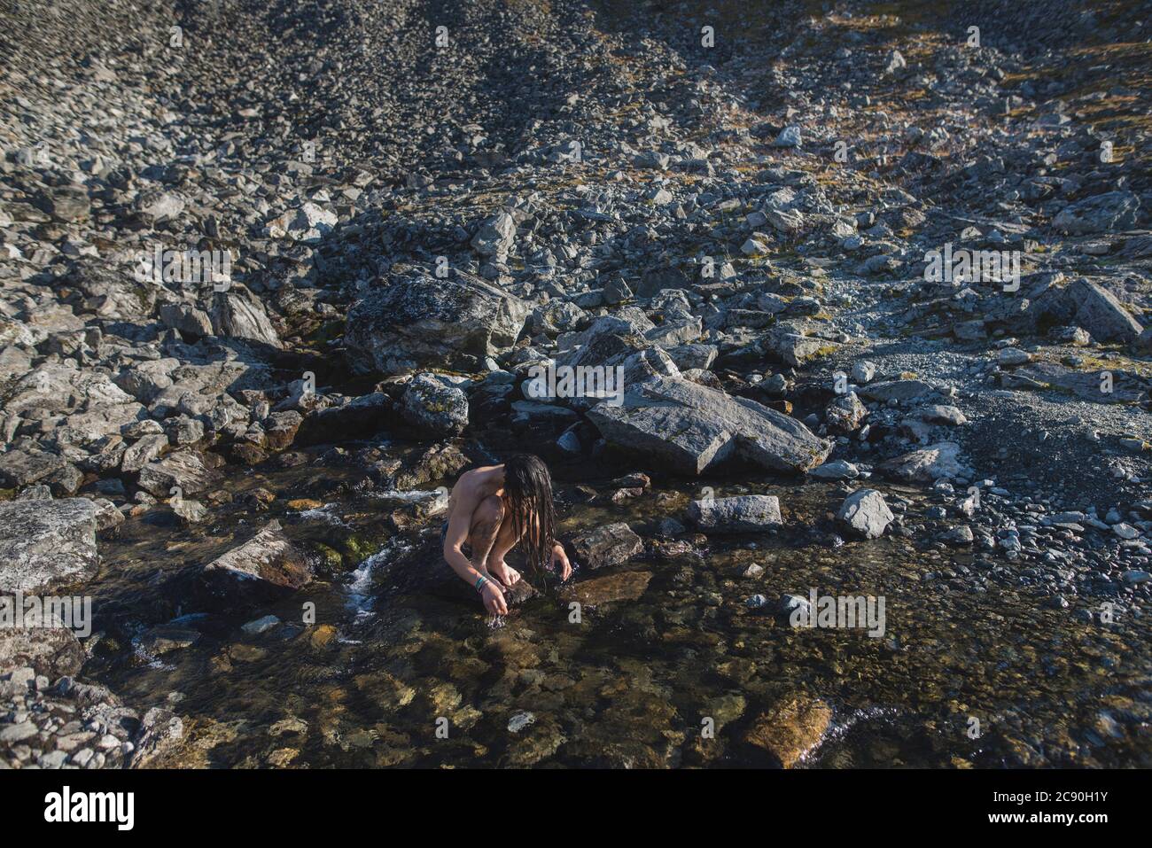 Norvège, homme se lavant les cheveux dans le ruisseau de montagne Banque D'Images