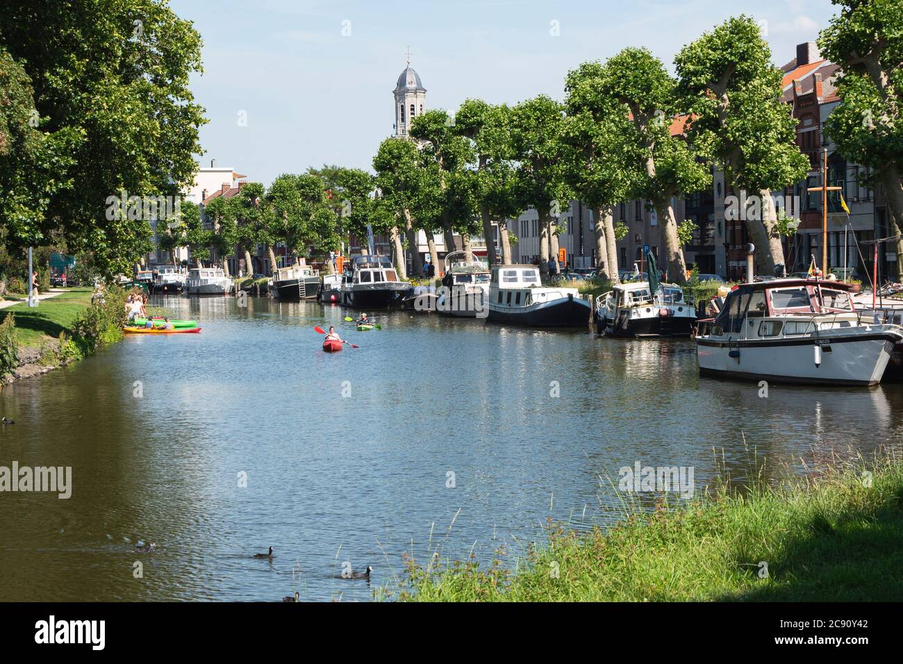 Lokeren, Belgique, 13 juillet 2020, les gens naviguent dans un canoë à côté de bateaux de plaisance amarrés dans le centre-ville Banque D'Images