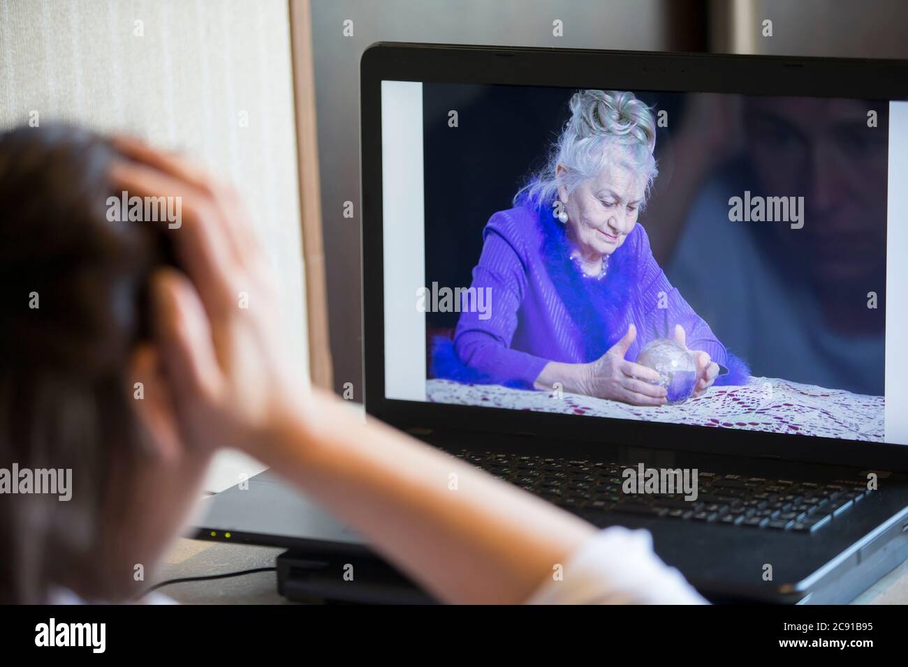 Une femme communique en ligne via un ordinateur portable avec un caissier de fortune. Banque D'Images