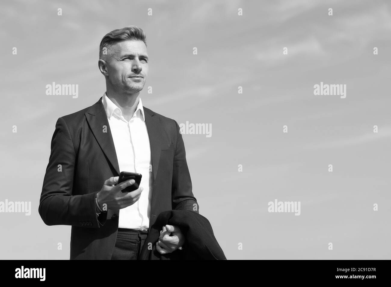 Communication mobile. Homme d'affaires réussi et motivé. Homme d'affaires bien entretenu coiffure. Prenez des décisions en déplacement. Concept d'entreprise. Vie d'affaires. Fond bleu ciel de style classique homme Banque D'Images