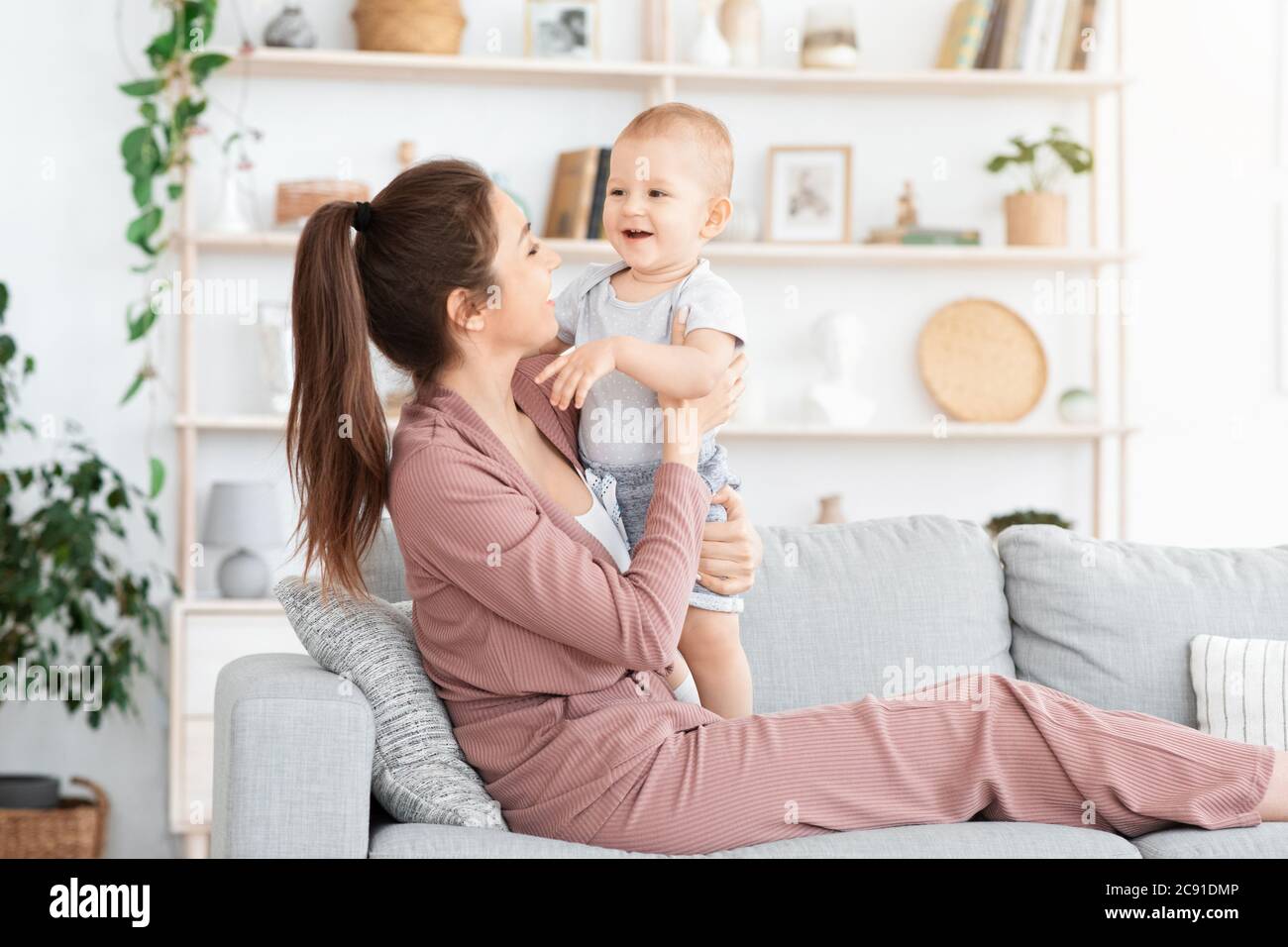 Un séjour agréable ensemble. Jeune maman qui se colle avec son bébé fils à la maison Banque D'Images