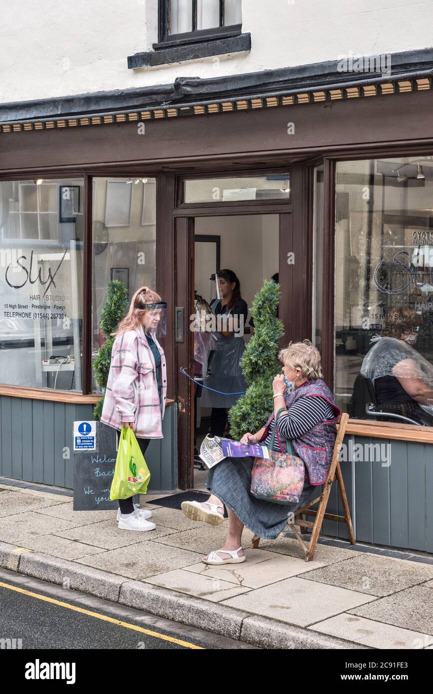 Clients attendant des rendez-vous à l'extérieur de Slix, le salon de coiffure local, car il rouvre après des mois de verrouillage à Presteigne, Powys, pays de Galles, Royaume-Uni Banque D'Images