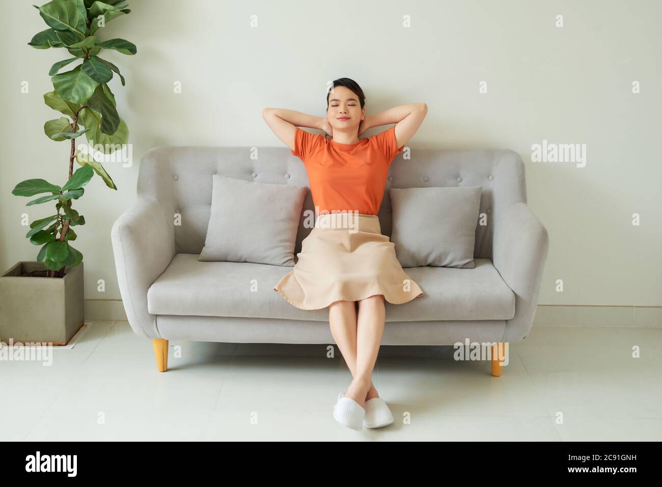 Calme et détendu femme au repos respirer de l'air frais sentir l'équilibre mental profiter du bien-être à la maison sur le canapé Banque D'Images