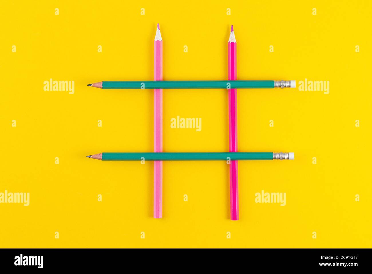 Affiche hashtag de crayons colorés croisés sur fond jaune. Médias sociaux et concepts de créativité avec hashtag signe fait de crayon. Espace de copie FLA Banque D'Images