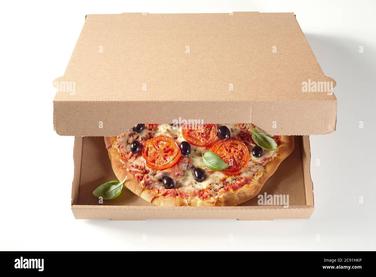 Savoureuse pizza italienne cuite au four dans une boîte de livraison rapide  en carton marron vue en grand angle avec une vue du couvercle non étiqueté  pour la marque et la publicité