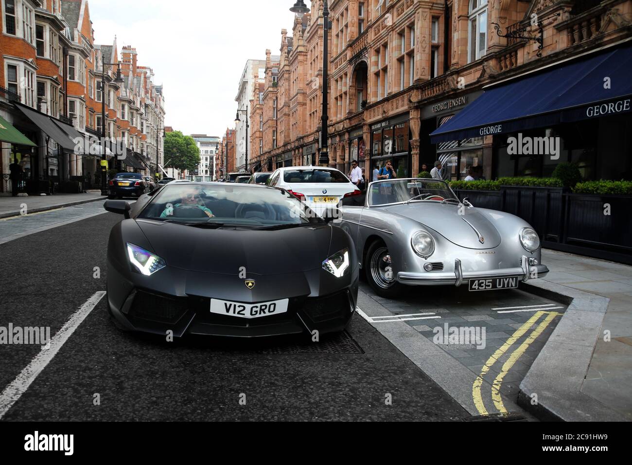 Black Matte Lamborghini Aventador Roadster Supercar moderne et Porsche 356 classique voiture de sport photographiée dans une rue du centre de Londres. Banque D'Images