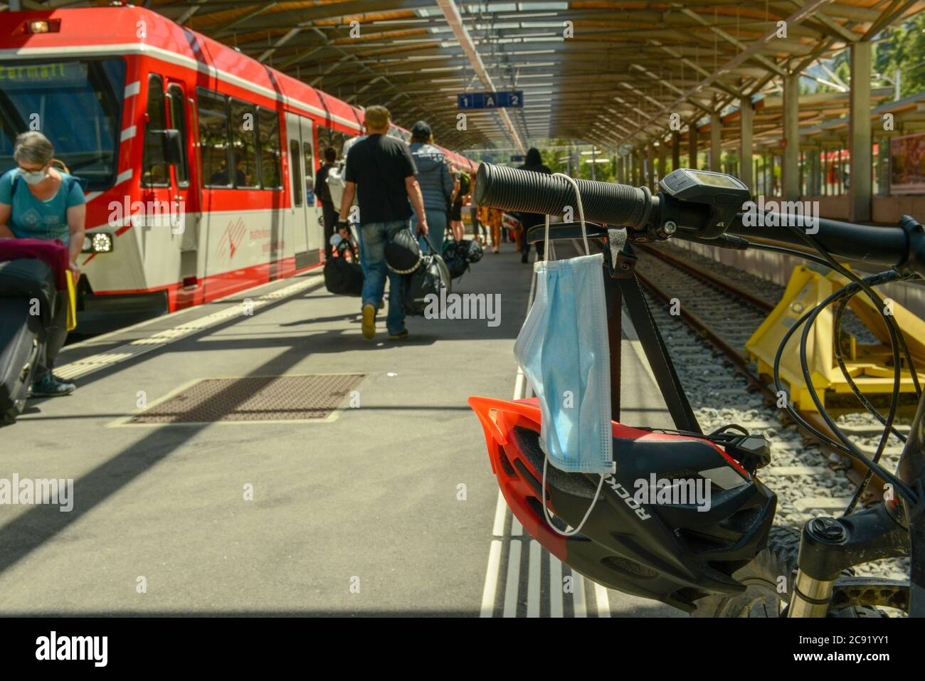 Zermatt, Suisse - 20 juillet 2020 : masque suspendu au guidon d'un vélo dans une gare Banque D'Images