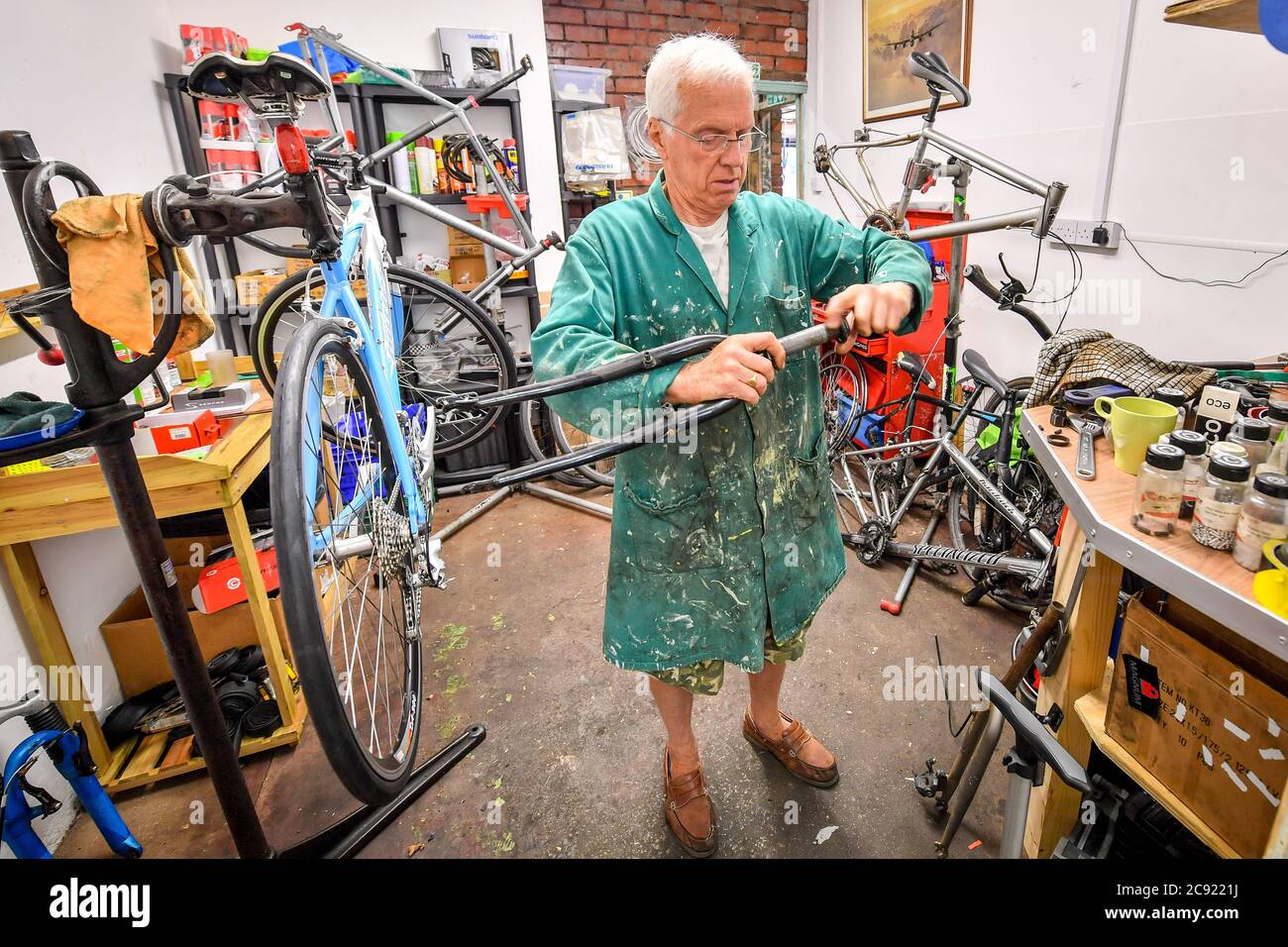 Paul Bradley, technicien de vélo à Briscycle, un centre indépendant de  réparation, de vente et de recyclage de vélos, répare la moto d'un client à  l'atelier de Brislington à Bristol, car l'atelier
