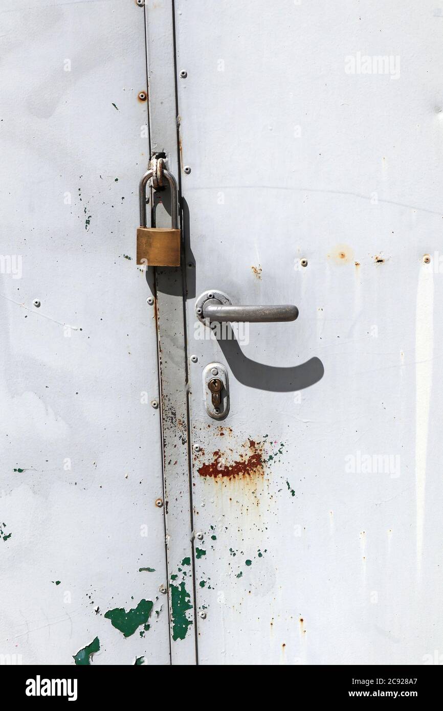 Porte en métal gris fermée par un cadenas Banque D'Images