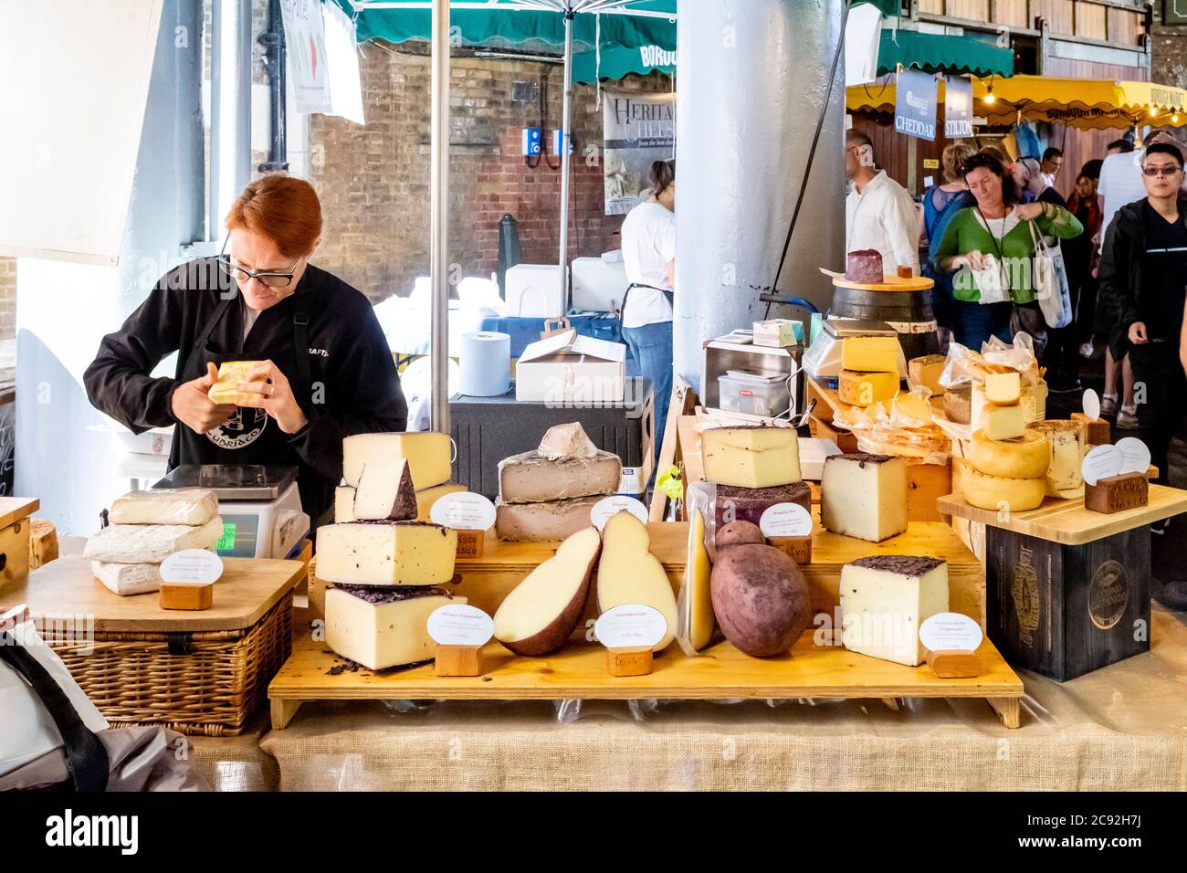 Une femme travaillant à UN Cheese Sall dans Borough Market, Londres, Angleterre. Banque D'Images