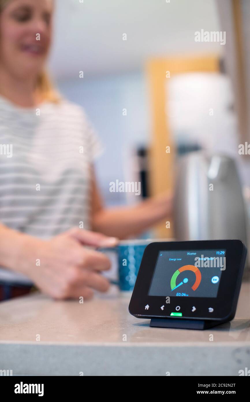 Femme au foyer électrique pour boisson chaude bouillante avec Smart Energy Meter en premier plan Banque D'Images
