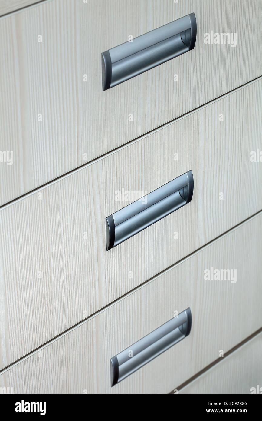 casiers de commode gros plan, texture d'un arbre de couleur blanche avec poignées grises. Banque D'Images
