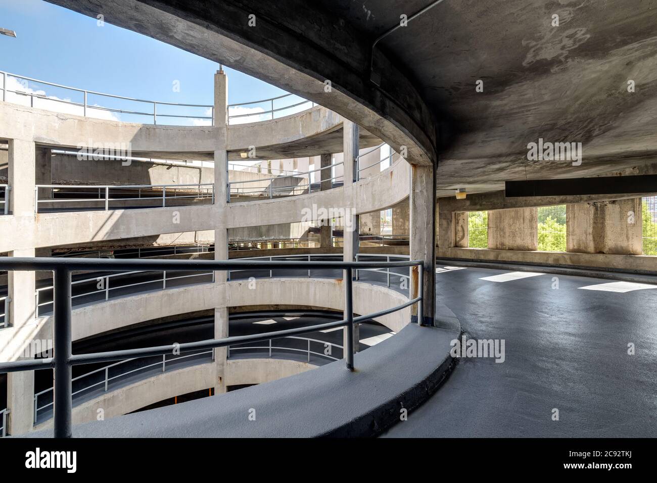 Une rampe en spirale dans un garage en béton. Banque D'Images