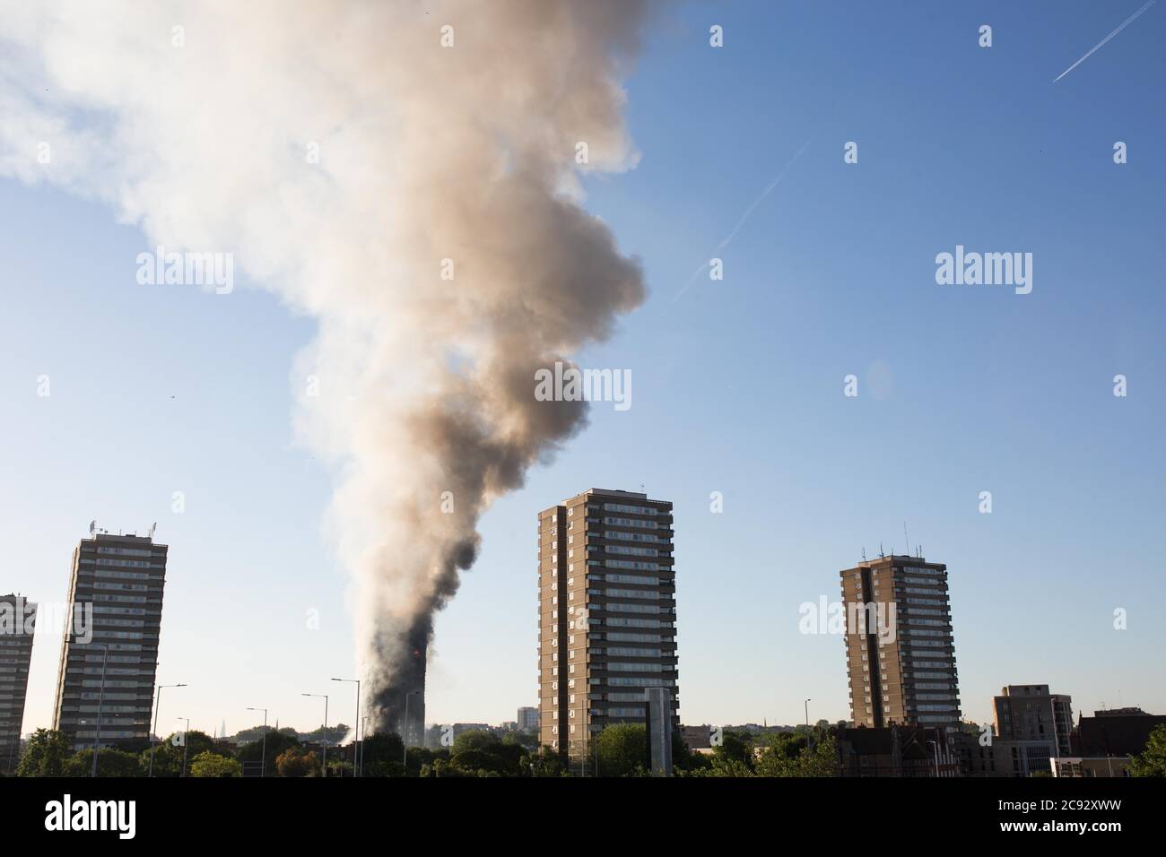 De la fumée s'élève à l'incendie de la Grenfell Tower, un immeuble de 24 étages faisant partie du Lancaster West Estate à North Kensington, Londres, Royaume-Uni. L'incendie a été déclenché tôt le matin par un réfrigérateur-congélateur défectueux au quatrième étage. Il s'étend rapidement à l'extérieur du bâtiment, par le revêtement extérieur et l'isolation. L'incendie a causé 72 morts, dont ceux de deux victimes qui sont plus tard décédées à l'hôpital. Plus de 70 autres personnes ont été blessées et 223 personnes ont échappé. C'était le feu structurel le plus meurtrier du Royaume-Uni depuis 1988 et le pire incendie résidentiel britannique depuis la Seconde Guerre mondiale Banque D'Images