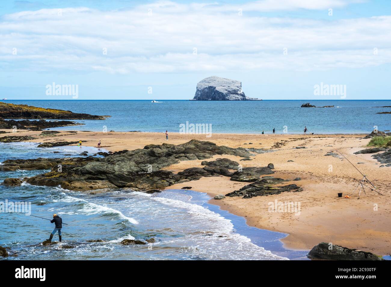 Pêcheur sur la flèche de sable à l'extrémité est de Milsey Bay North Berwick avec Bass Rock en arrière-plan, East Lothian, Écosse, Royaume-Uni Banque D'Images