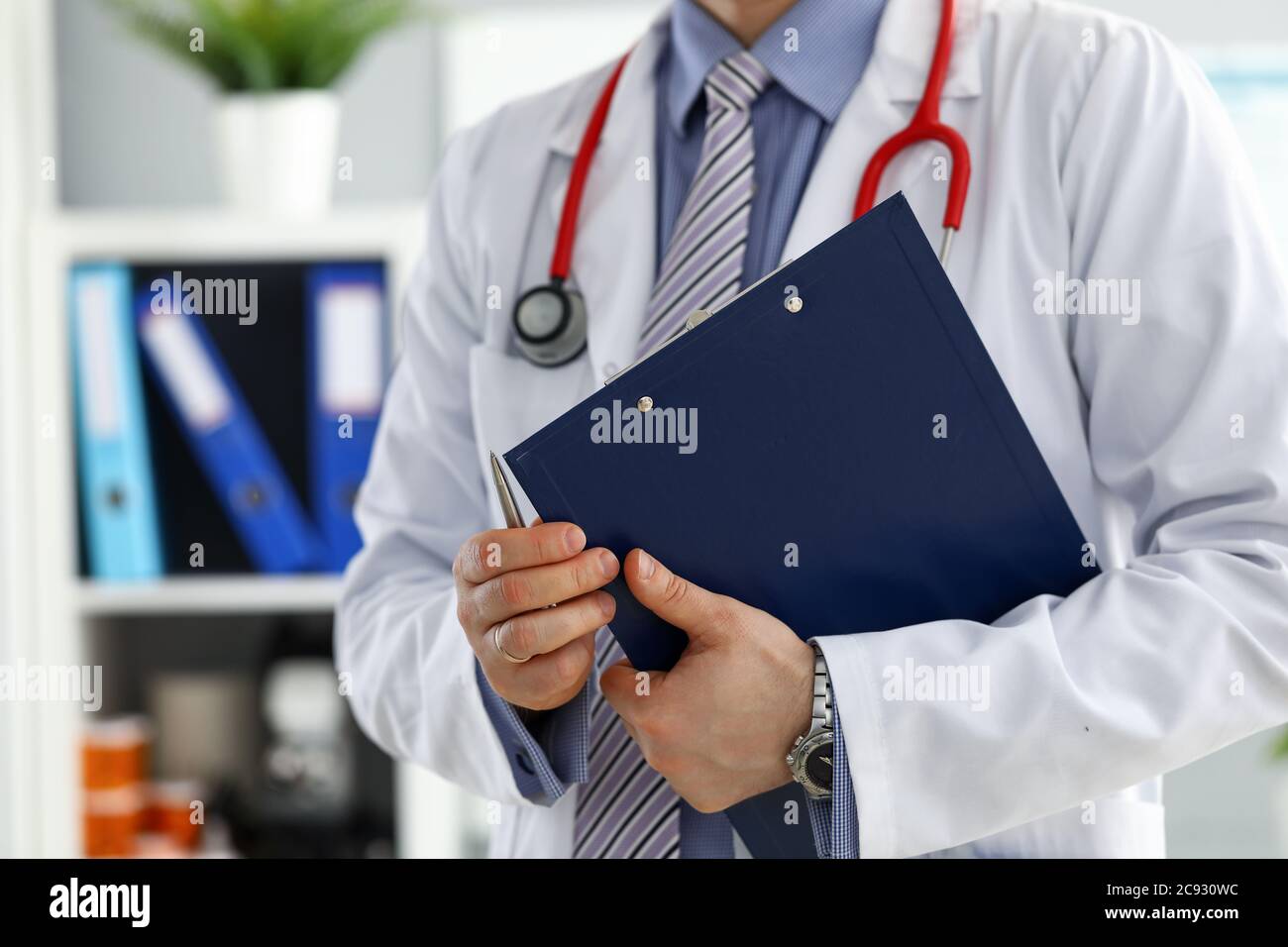 Un médecin de sexe masculin tient dans les mains du presse-papiers de près Banque D'Images