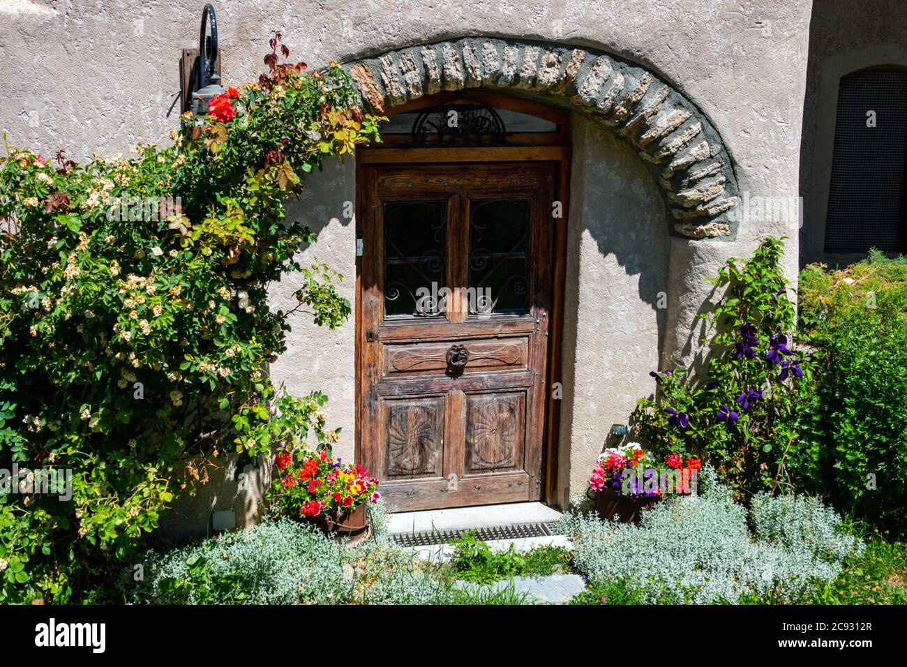 Porte pittoresque avec arcades et fleurs dans le petit village du Casset,  au bord de la rivière Guisane, serre Chevalier, près de Briançon, Ecrins,  France Photo Stock - Alamy