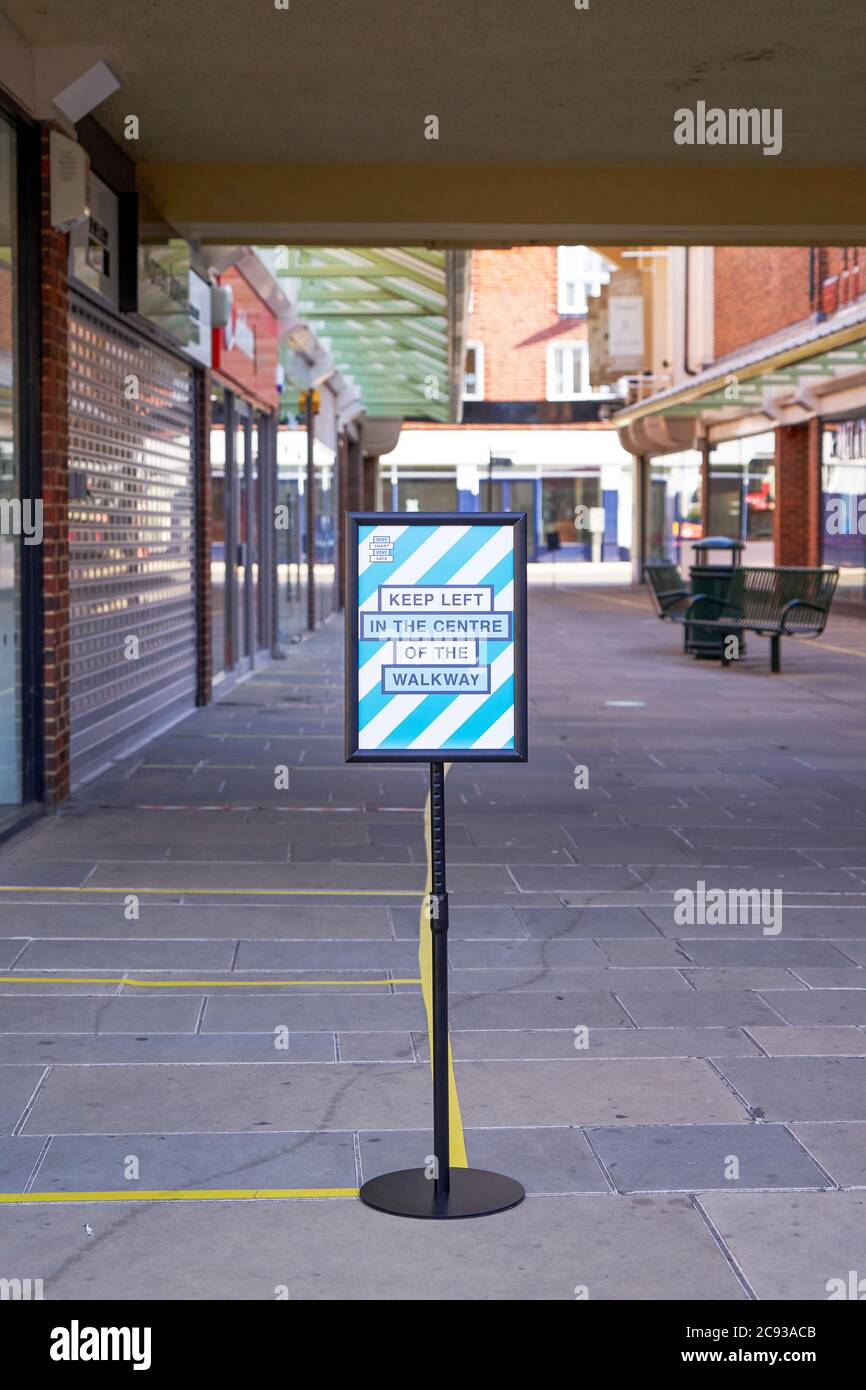 Panneau indiquant aux piétons de marcher vers la gauche dans le centre commercial pour encourager la distanciation sociale Banque D'Images