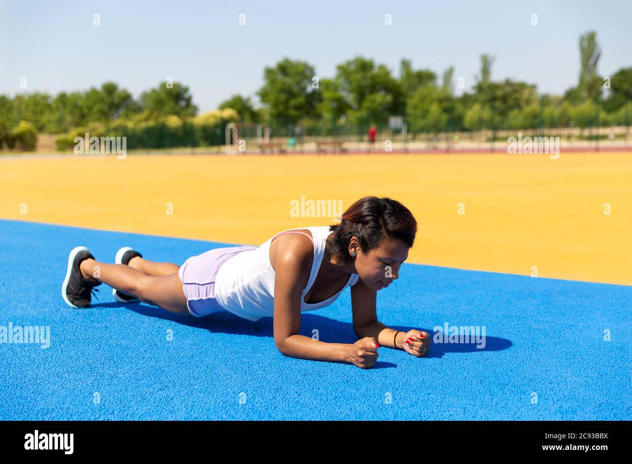 Athlète féminine faisant des abdominaux dans les installations sportives en plein air. Espace pour le texte. Concept de sport et de vie saine. Banque D'Images