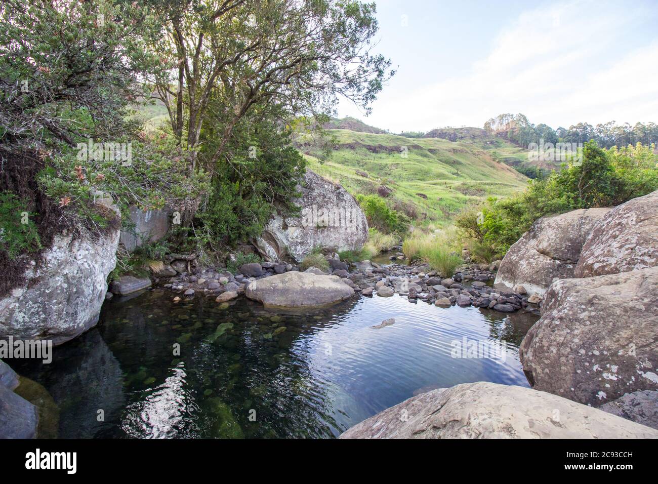 Une piscine tranquille, entourée de grands rochers de basalte dans le ruisseau Sterkspruit, dans les montagnes du Drakensberg, en Afrique du Sud Banque D'Images