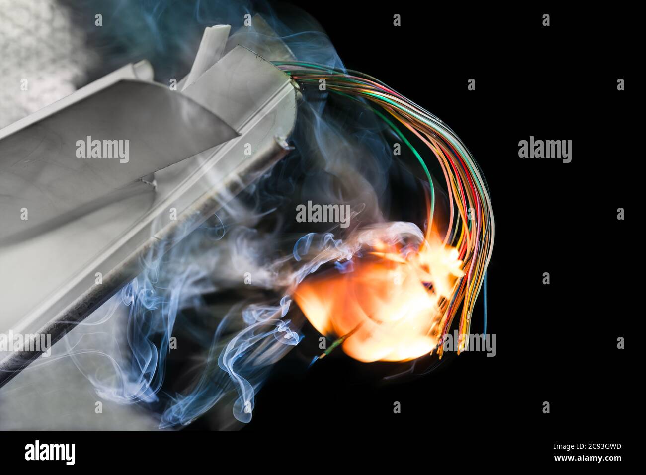 Câbles électriques de couleur flamboyante dans les épaves endommagées sur fond noir. Incendie de câblage dans des pièces métalliques ou en plastique. Collision aérienne ou ferroviaire. Banque D'Images