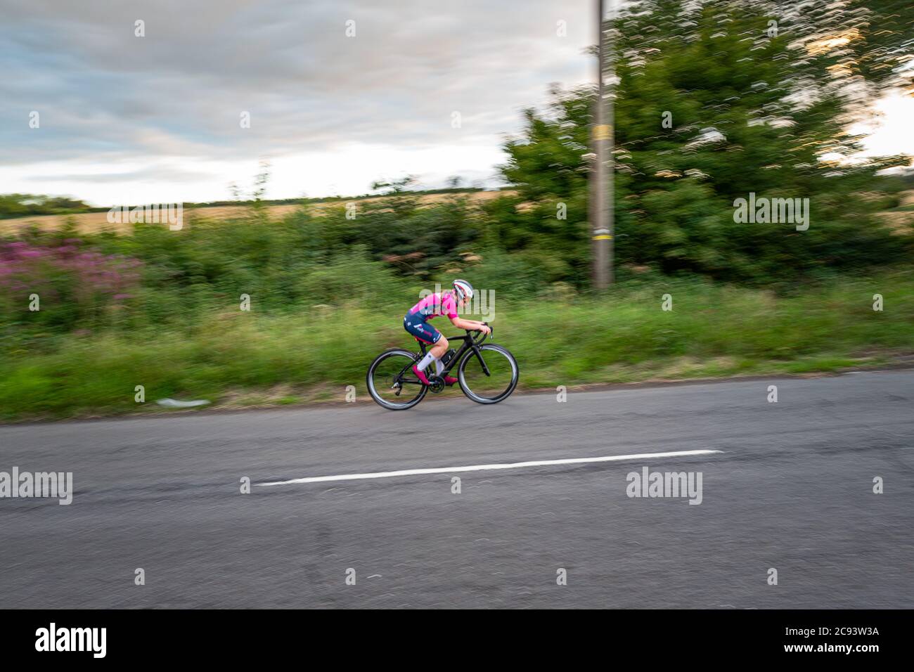 Le cycliste fait son chemin dans une course sur route dans les régions rurales de l'Angleterre Banque D'Images