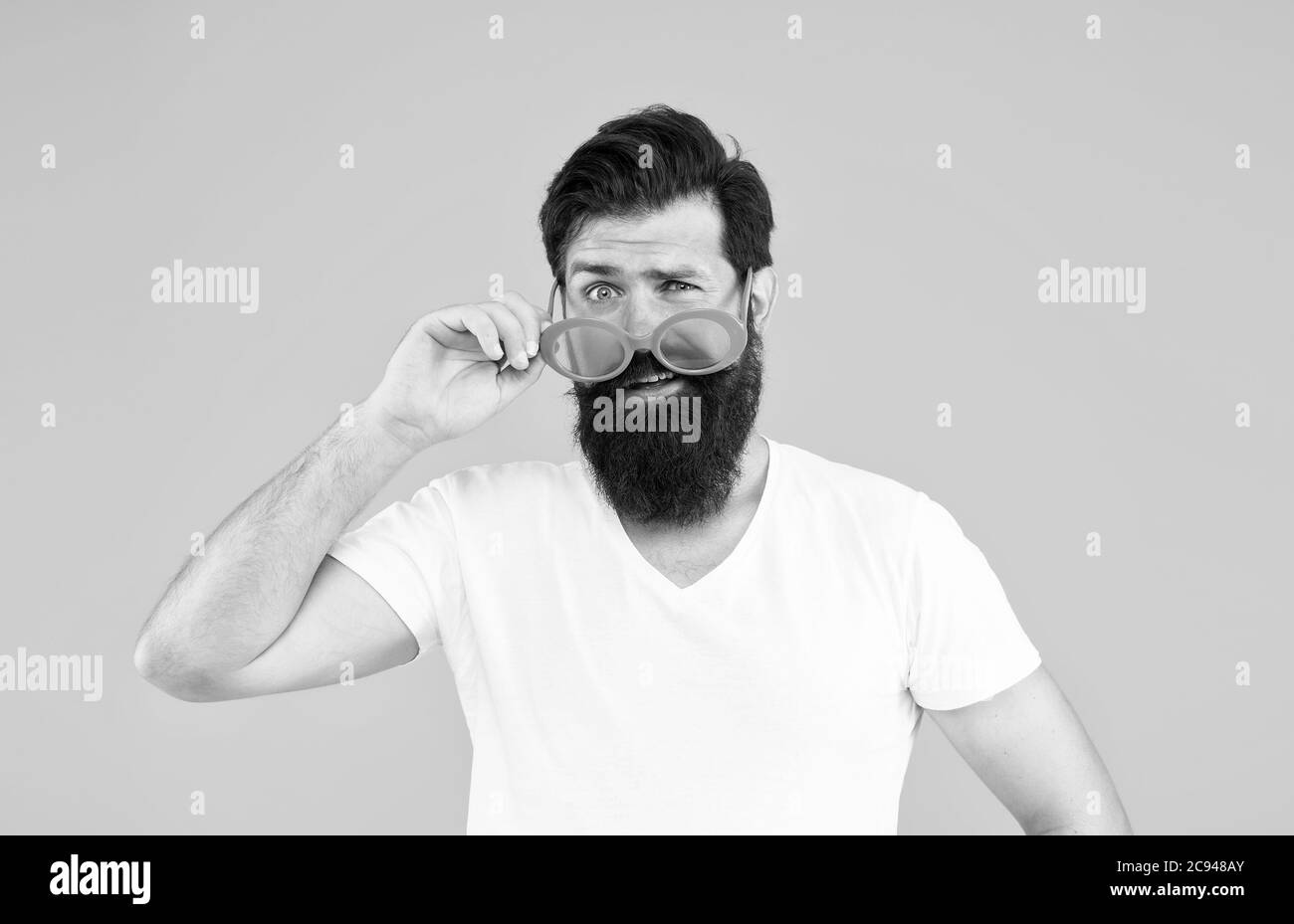 Accessoire adapté à votre style. Look hipster à travers des lunettes de fantaisie. Accessoire de fête de la mode. Port d'un accessoire oculaire avec filtre couleur. Homme barbu avec look de fête dans un accessoire tendance Banque D'Images
