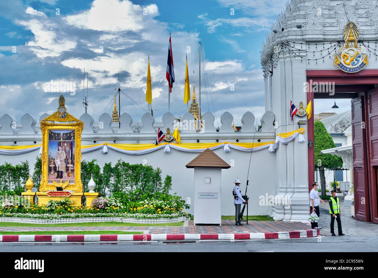 La mousson surmonte l'entrée du Grand Palais et de Wat Phra Kaew, avec une garde royale et un portrait du roi Maha Vajiralongkorn ; Bangkok, Thaïlande Banque D'Images