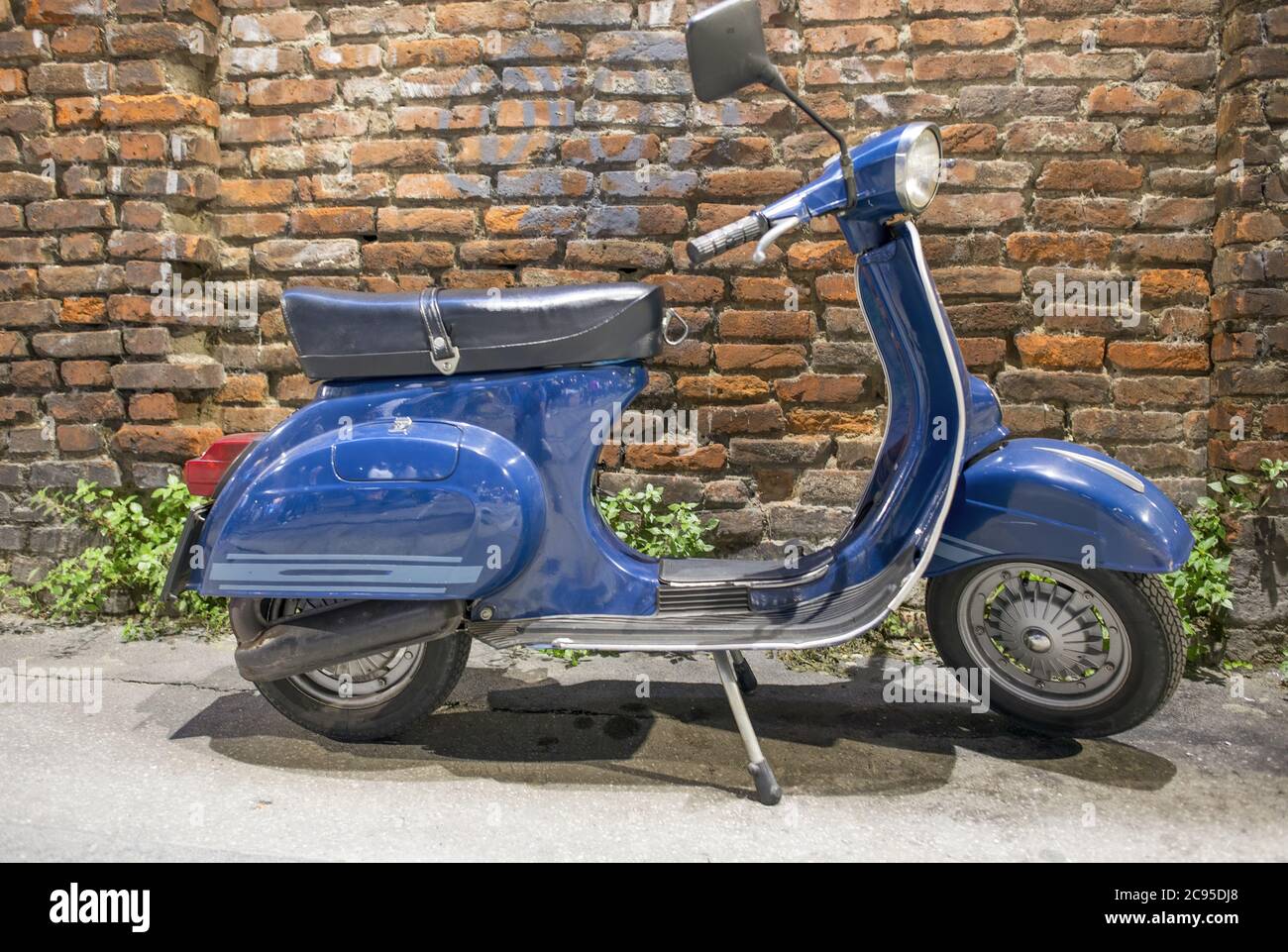 Moto italienne bleu vintage avec mur ancien en brique sur fond Photo Stock  - Alamy